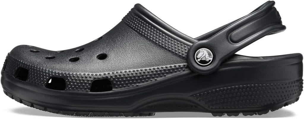 Side view of Crocs Classic Clogs in black on summer pavement